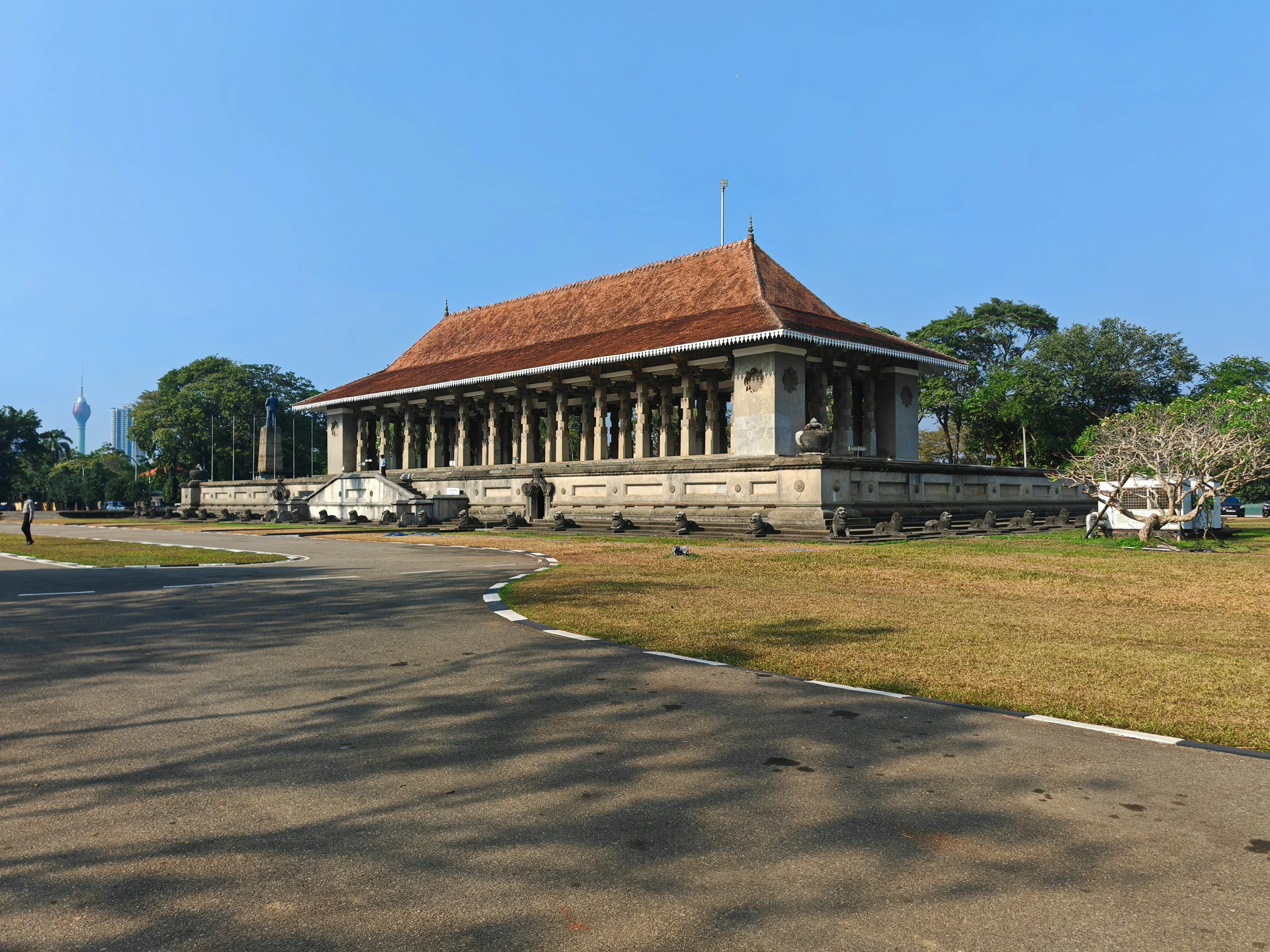 A columned monument with an orange tiled roof beneath blue sky