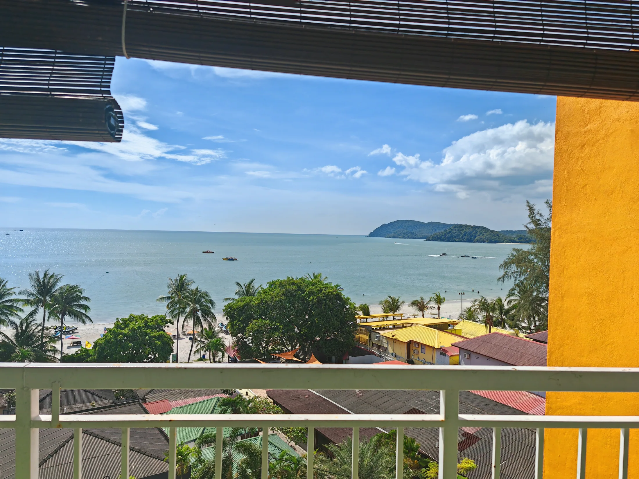 A balcony view over trees, beach and sea in Langkawi