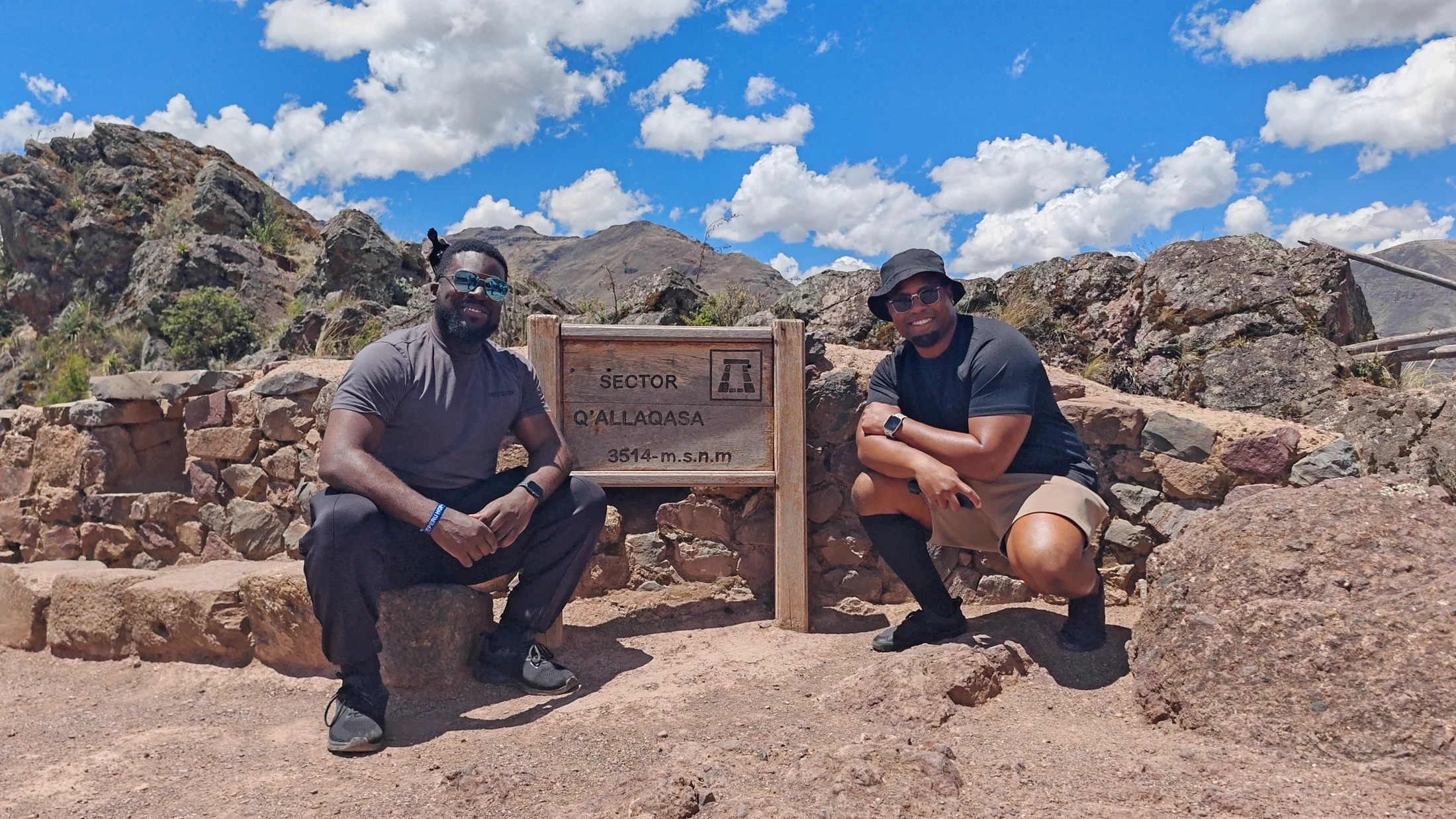 Two travellers beside ancient stone walls in the Cusco region